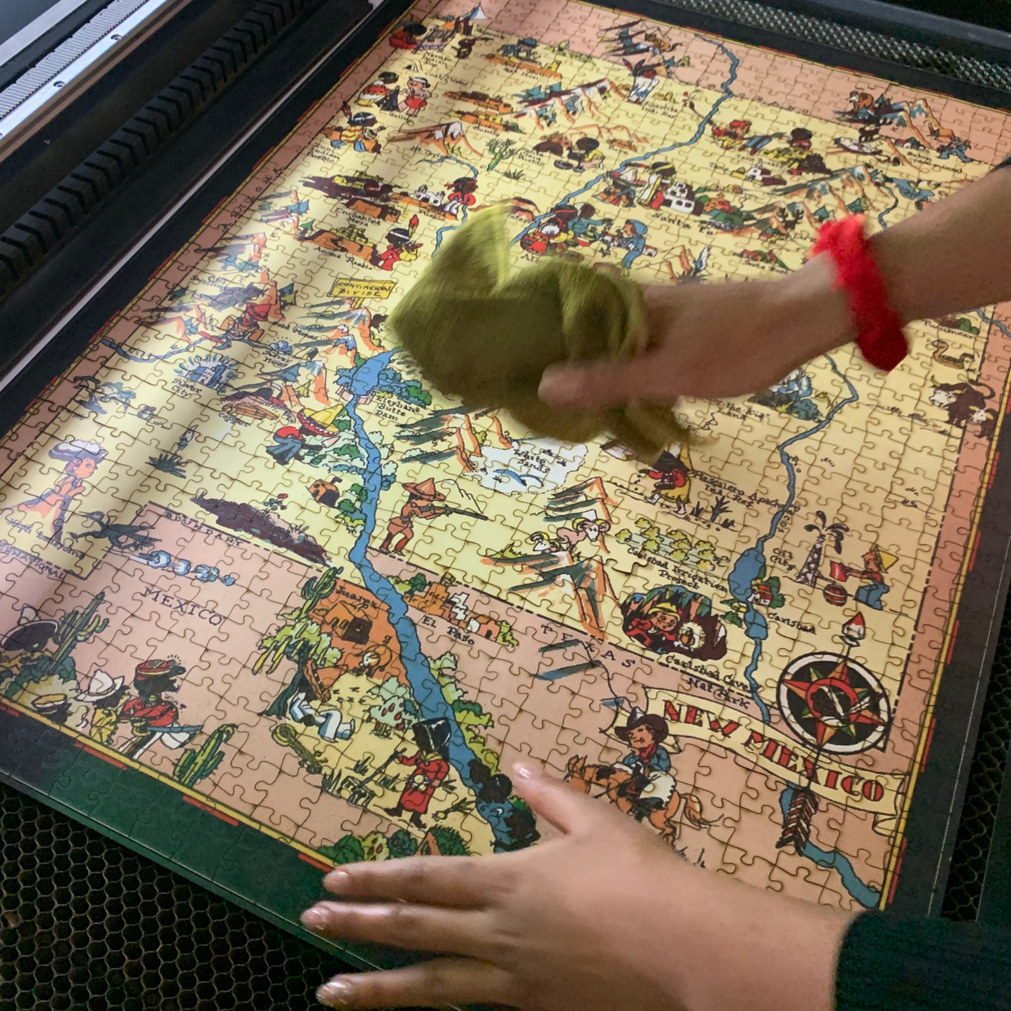 Wiping laser-cut wooden map puzzle. Handcrafted jigsaw finish.